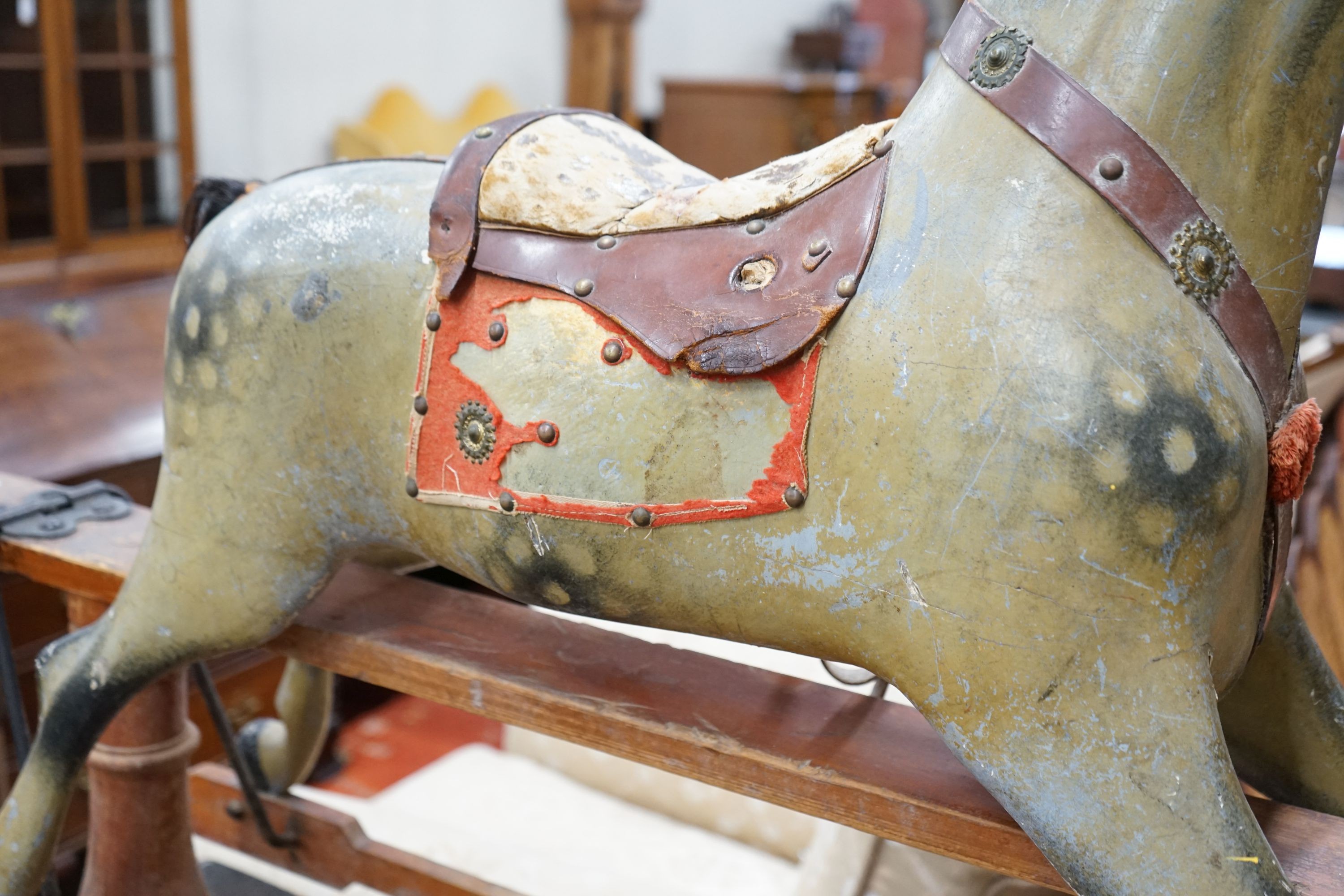 An Edwardian carved wood and dapple painted rocking horse, raised in a trestle frame, length 127cm, height 95cm